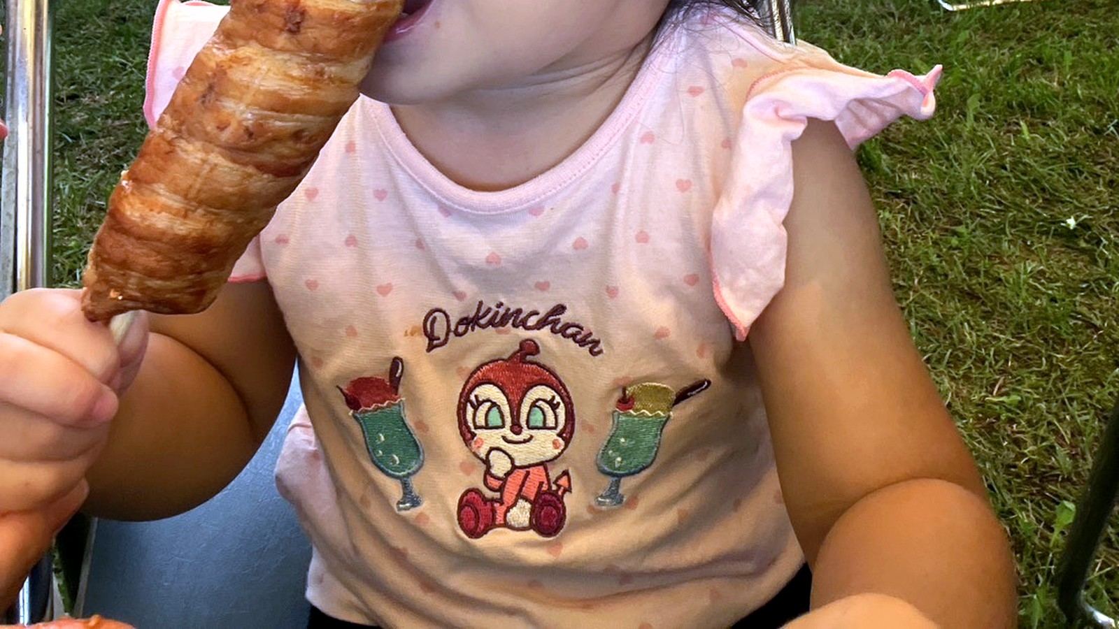 肉巻きおにぎり棒を頬張る子ども
