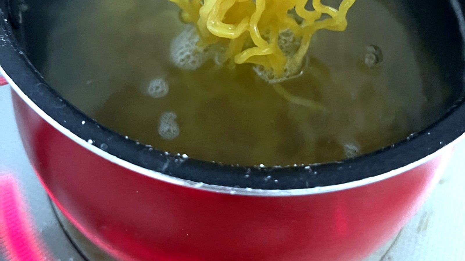 鍋で茹でられる中華麺の持ち上げ