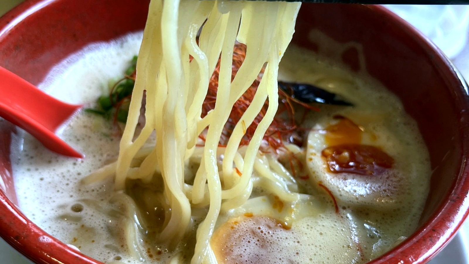 箸で麺を持ち上げた濃厚ラーメン