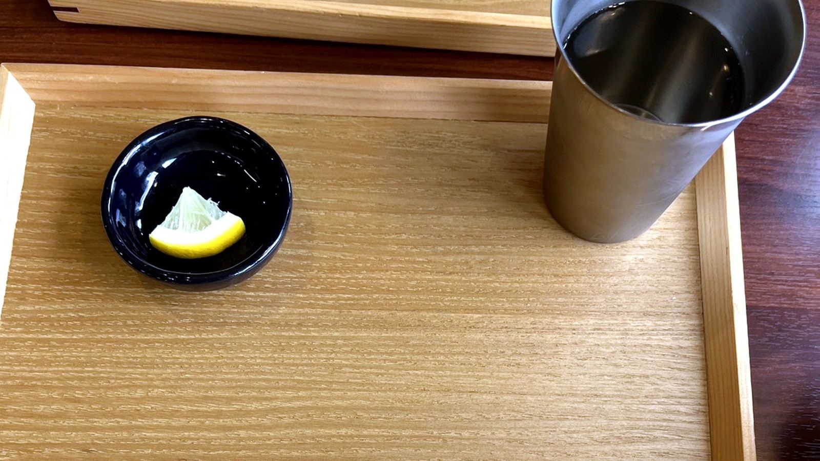 木製トレーに置かれた箸とおしぼりと水