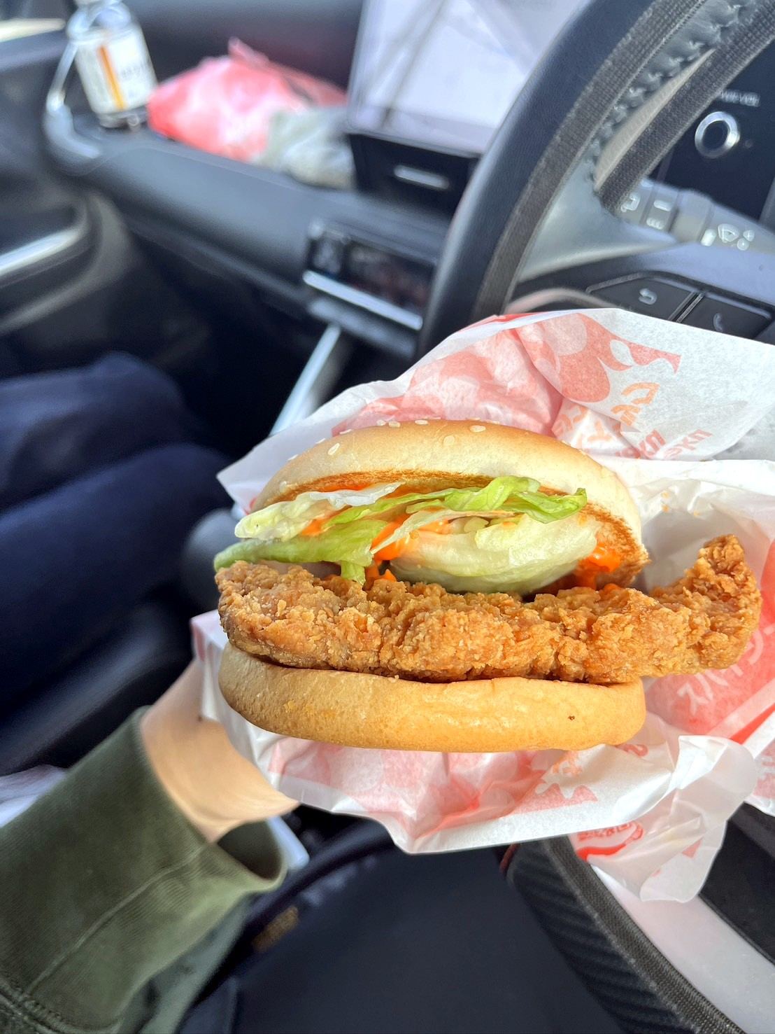 車内で手に持ったチキンバーガー