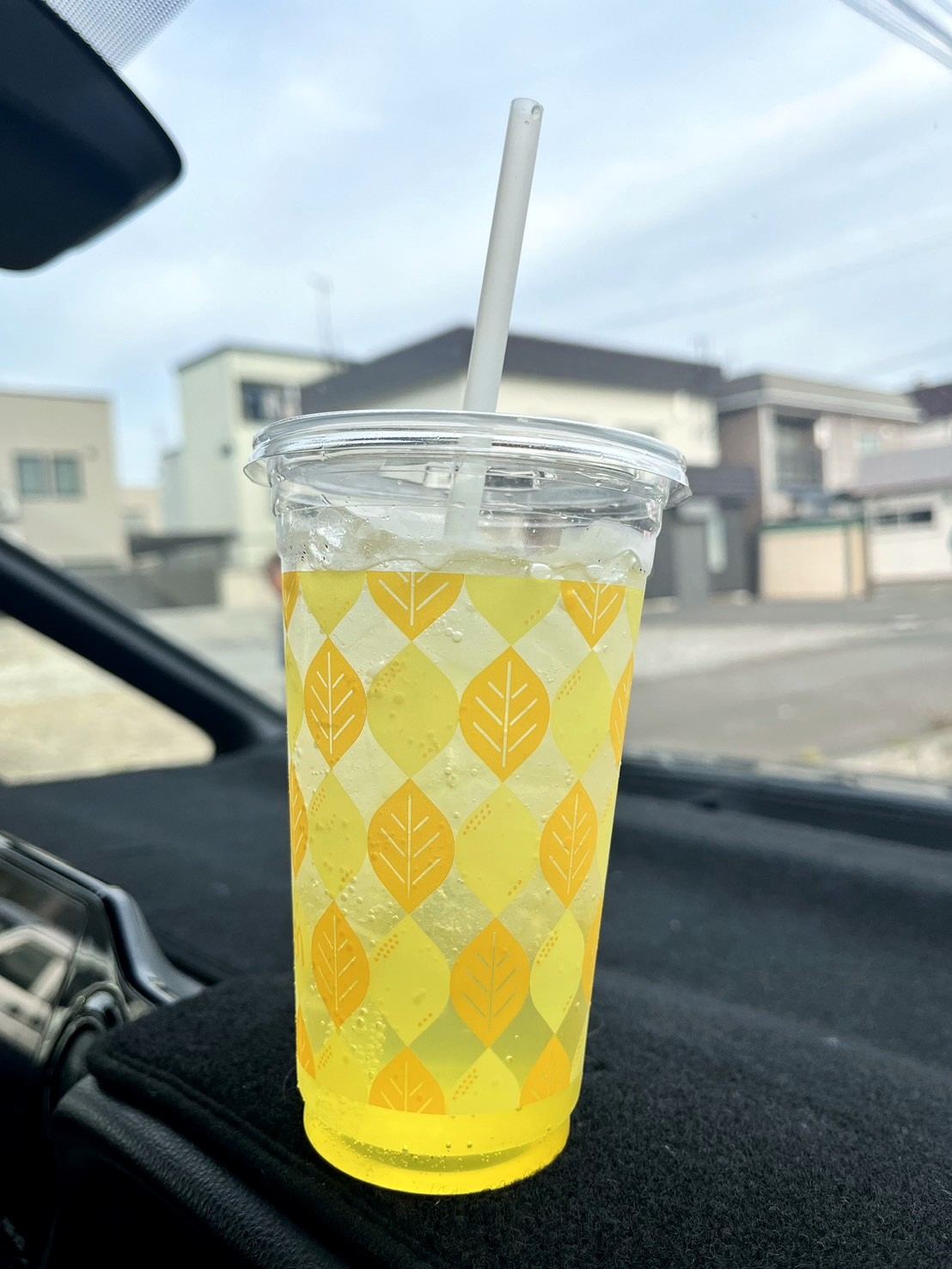 車のダッシュボードに置かれた黄色い炭酸ドリンク