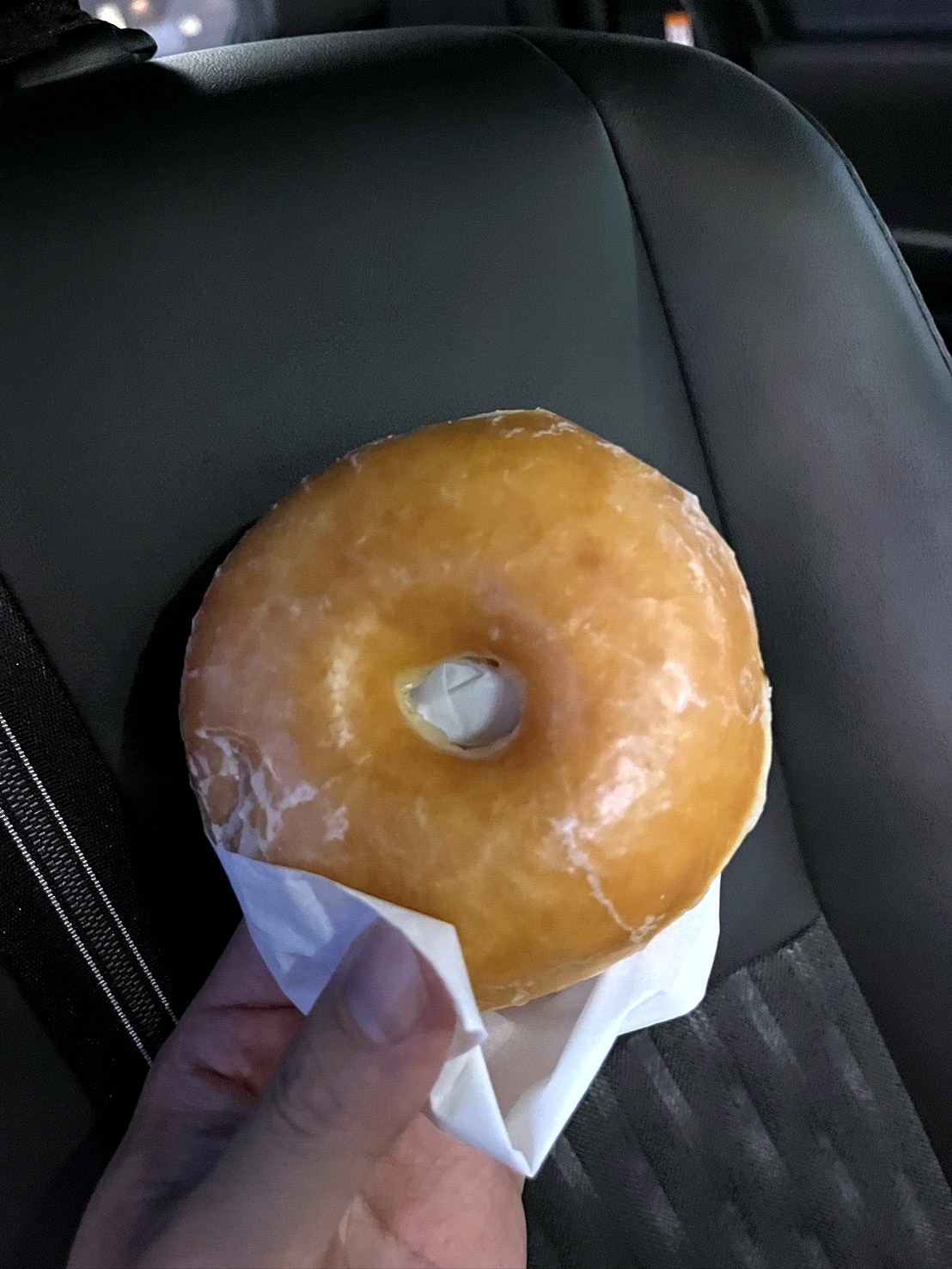 車内で手に持ったグレーズドドーナツ