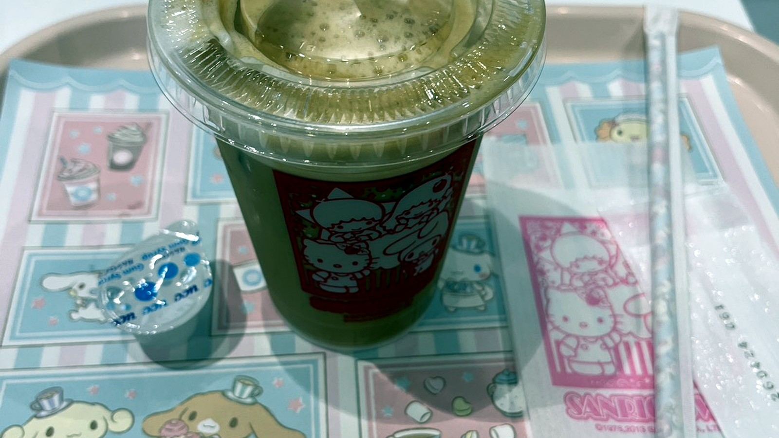 サンリオデザインのトレーに置かれたアイスカフェラテ