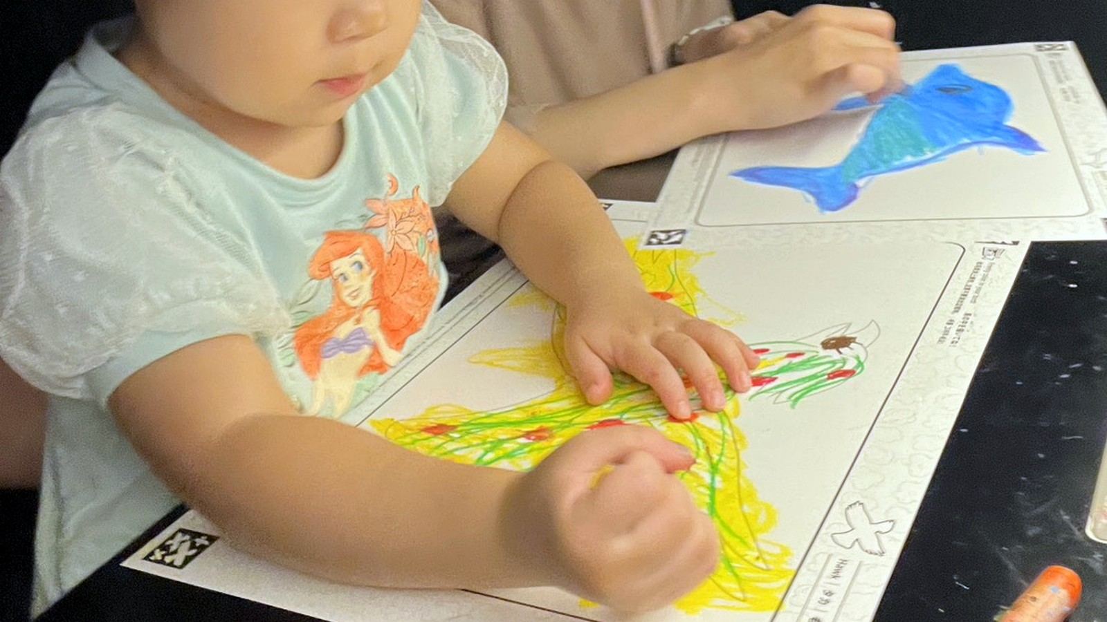 親子で並んでぬり絵を楽しんでいる様子