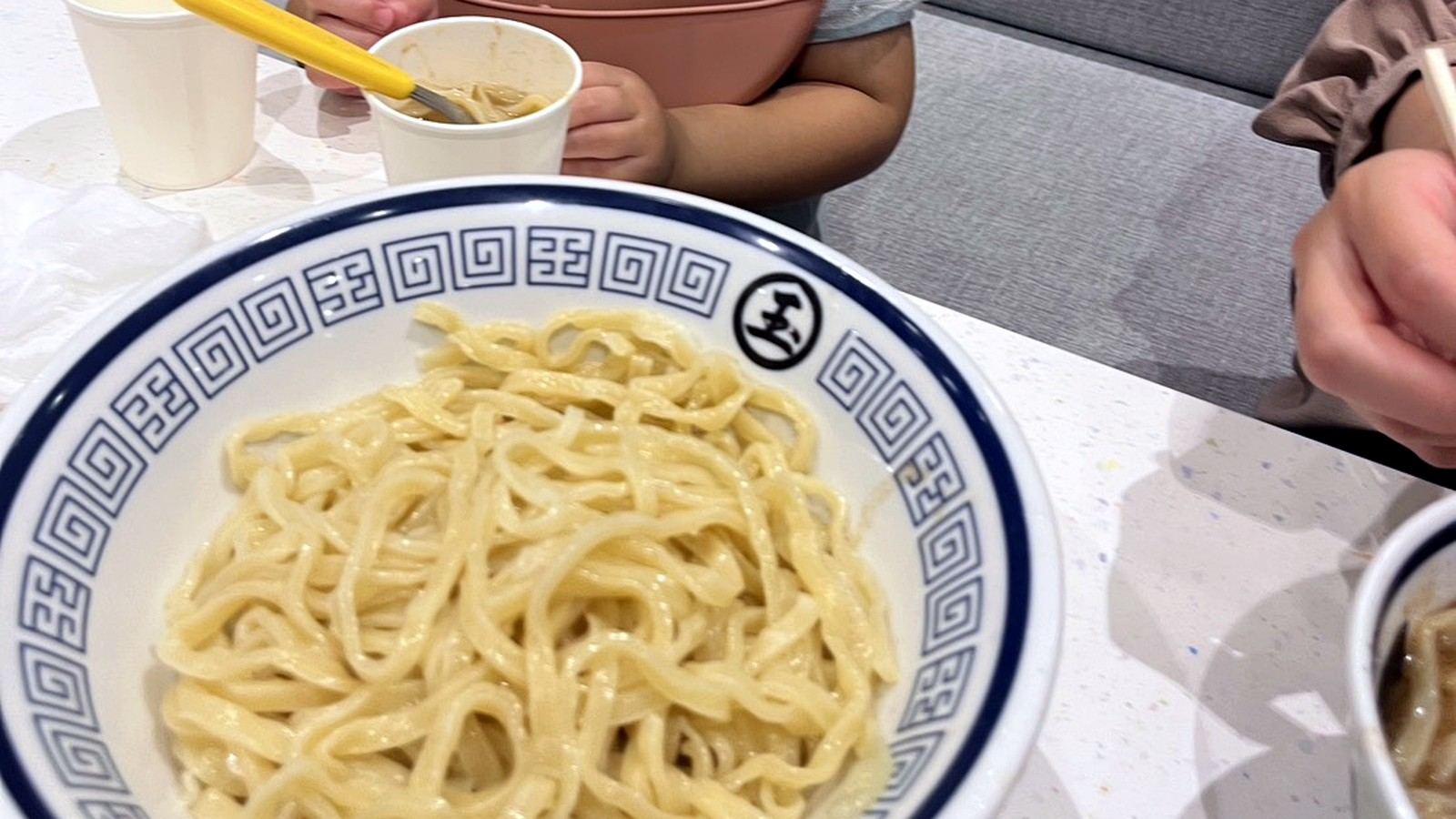 ラーメン店で食事をする小さな子ども