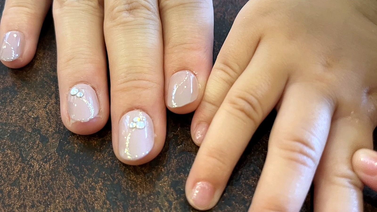 ジェルネイルを施した大人の手と子供の手