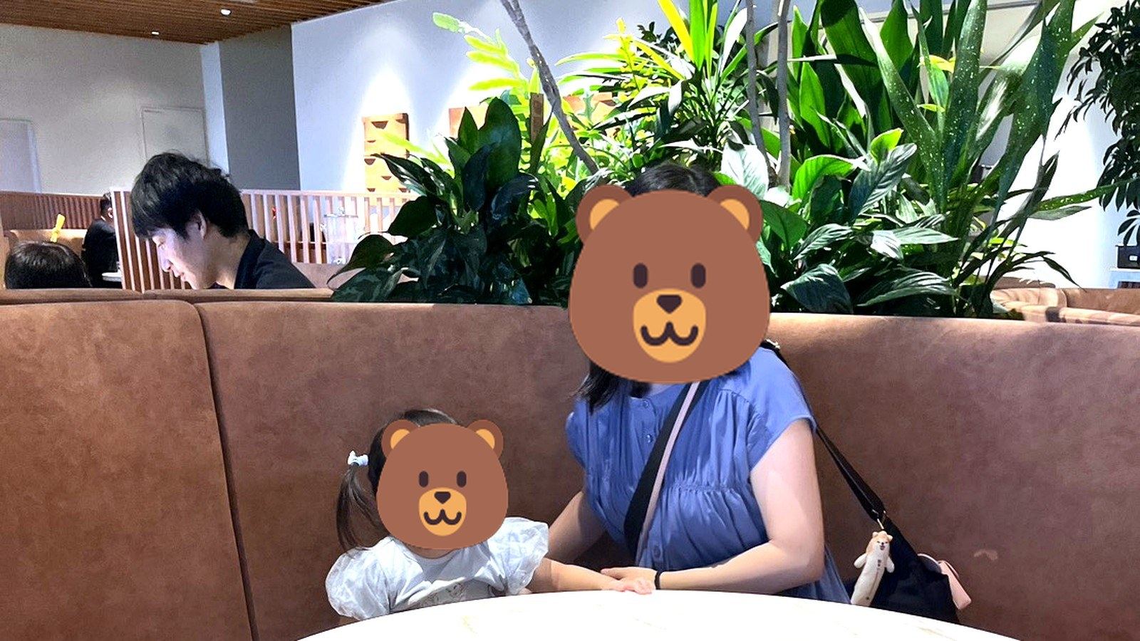 レストランのボックス席に座る母親と小さな子ども
