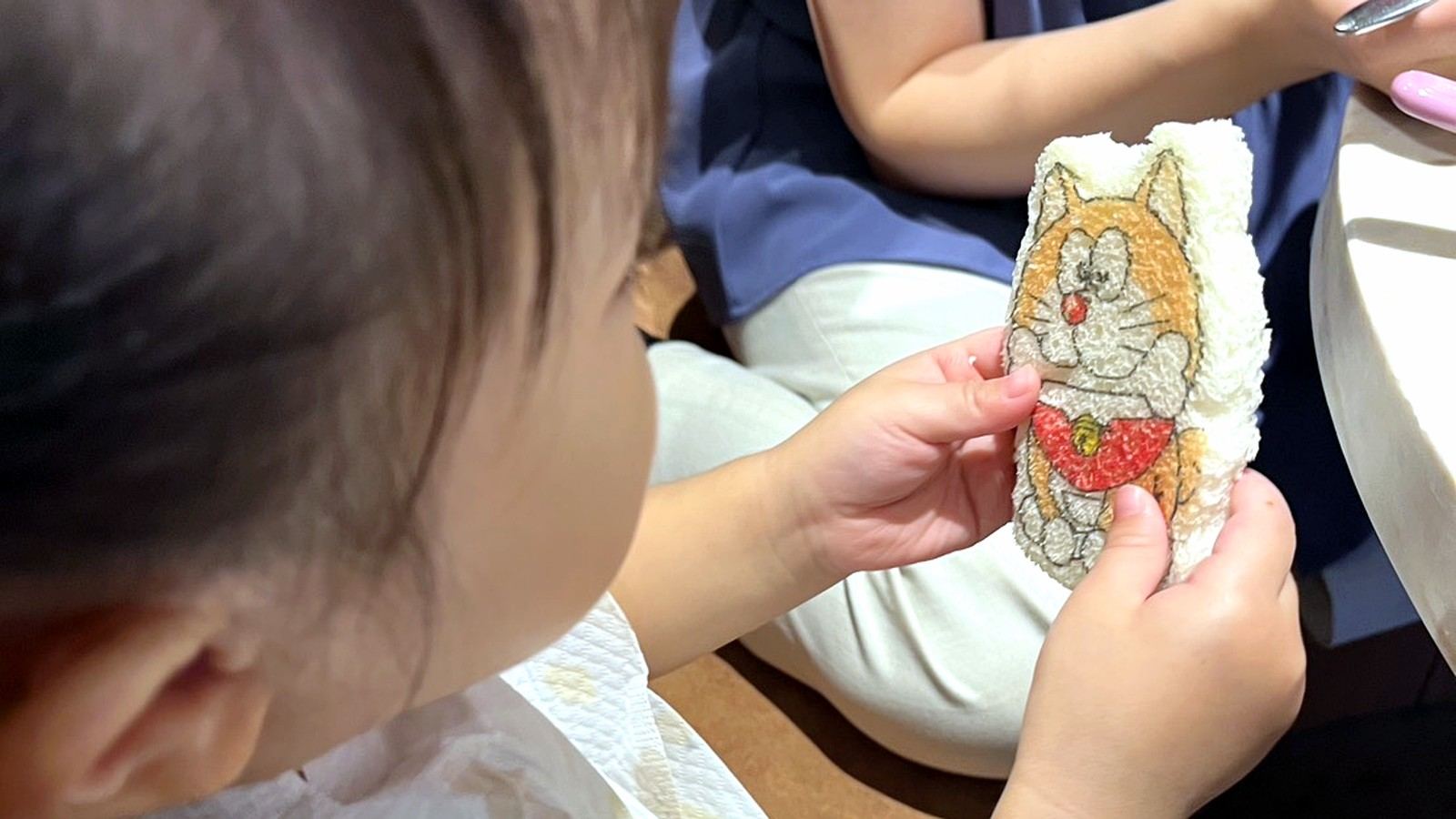 イラストが描かれたおしぼりを持つ子ども