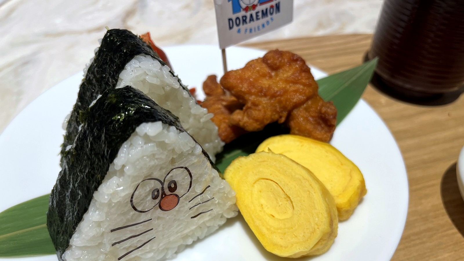 ドラえもん風の三角おにぎりと唐揚げ、卵焼き