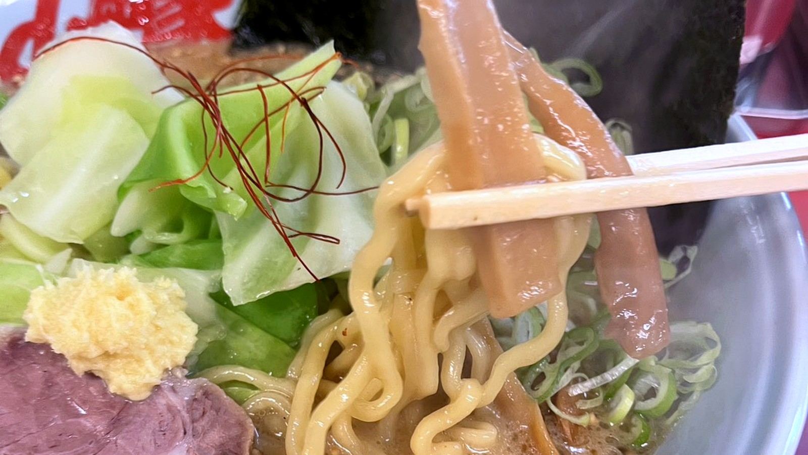 箸で麺とメンマを持ち上げた山岡家のラーメン